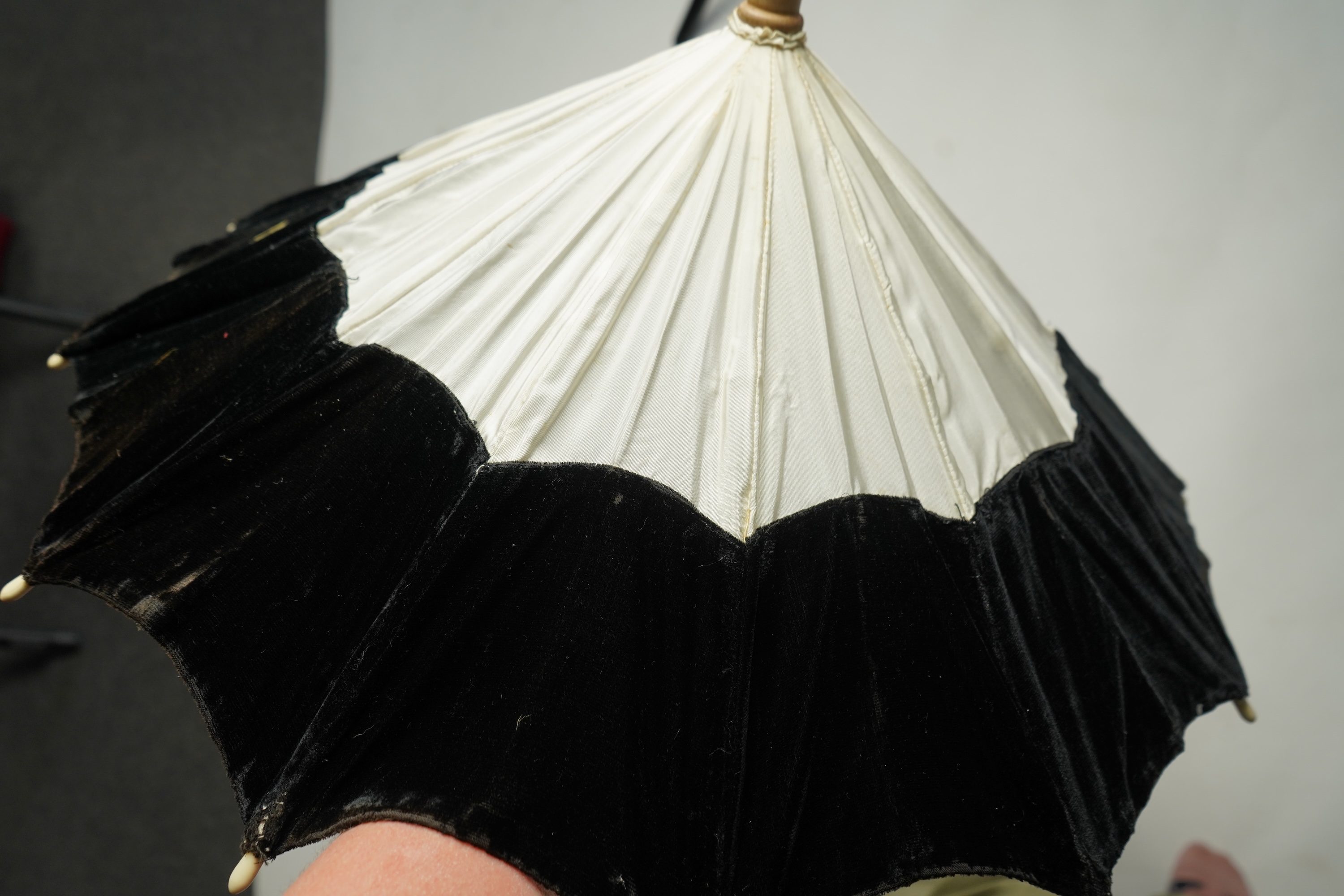An unusual early 20th century cream silk and black velvet parasol and silk corded tassel. 64cm high. Condition - good